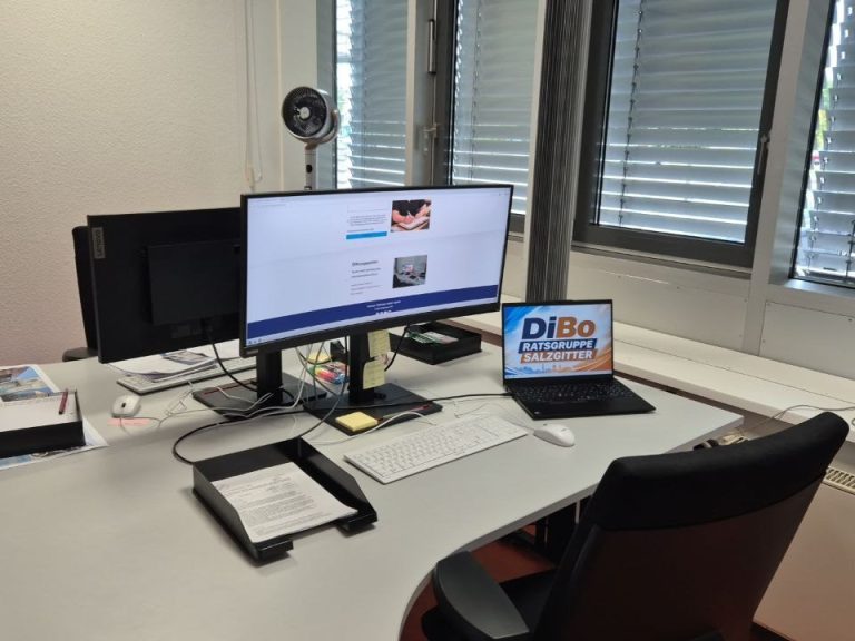 DiBo Salzgitter Büro mit zwei Monitoren, Schreibtisch und Drehstühlen, Fenster mit Tageslicht.